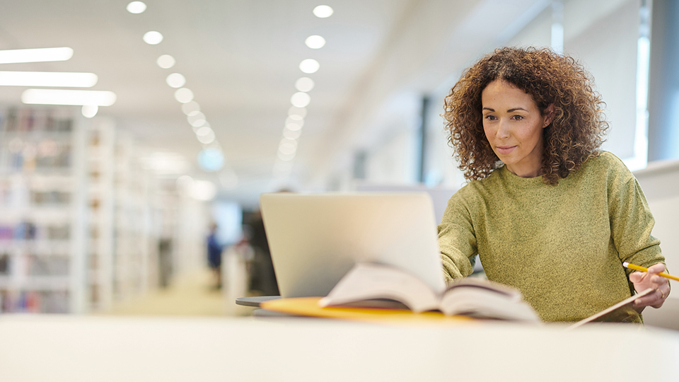 Woman in library on laptop