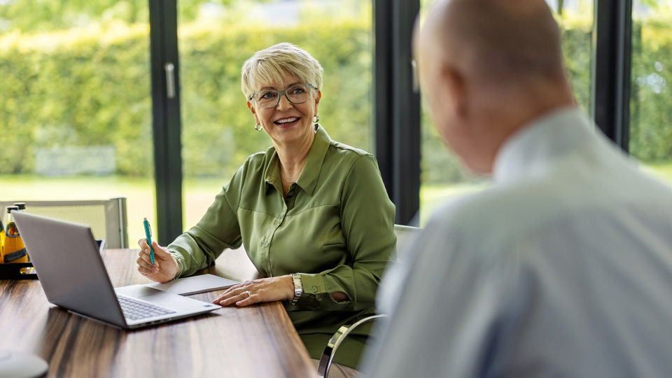 Meeting situation with a woman and a man in front of a notebook computer